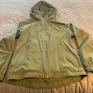 Lululemon green rain jacket with lining and hood tucked in collar.